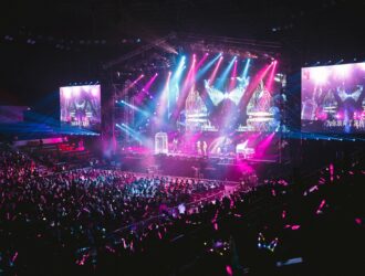 Colorful live concert with vibrant lighting, energetic crowd, and dynamic stage performance.